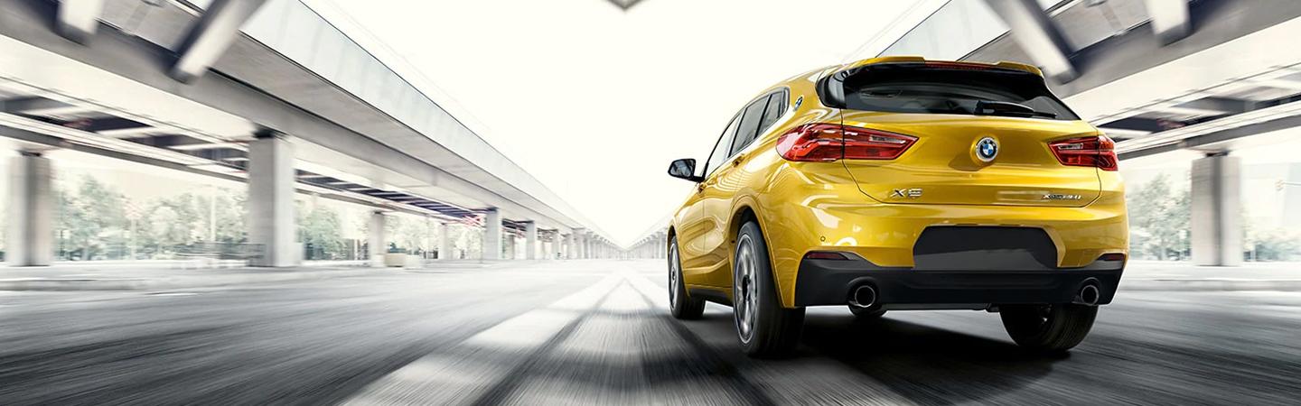 Back view of a 2023 BMW X2 driving on the road