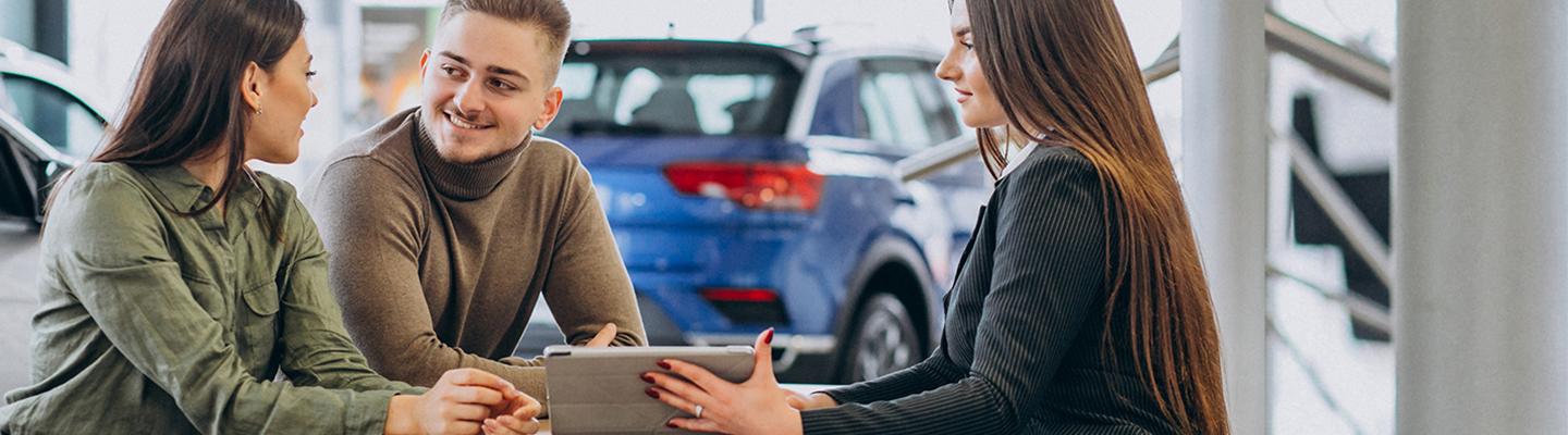 Woman and Man talking with Woman car salesperson in dealership