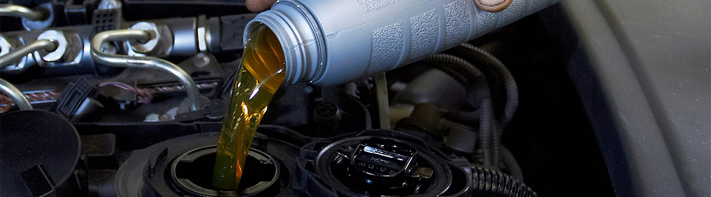 pouring oil into car engine