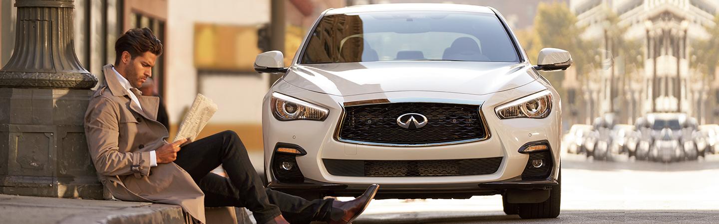2022 INFINITI Q50 parked by man reading newspaper