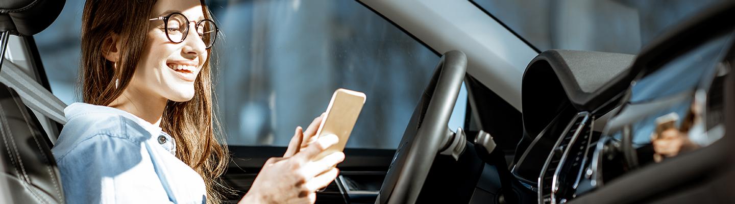 Woman looking at phone in car